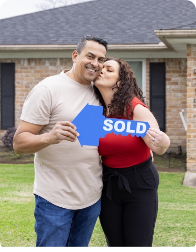 Couple holding sold sign